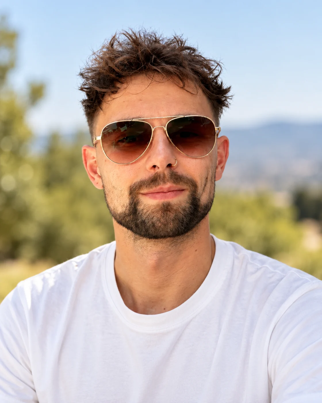 Andre Deters im Freien vor Bäumen und Hügeln